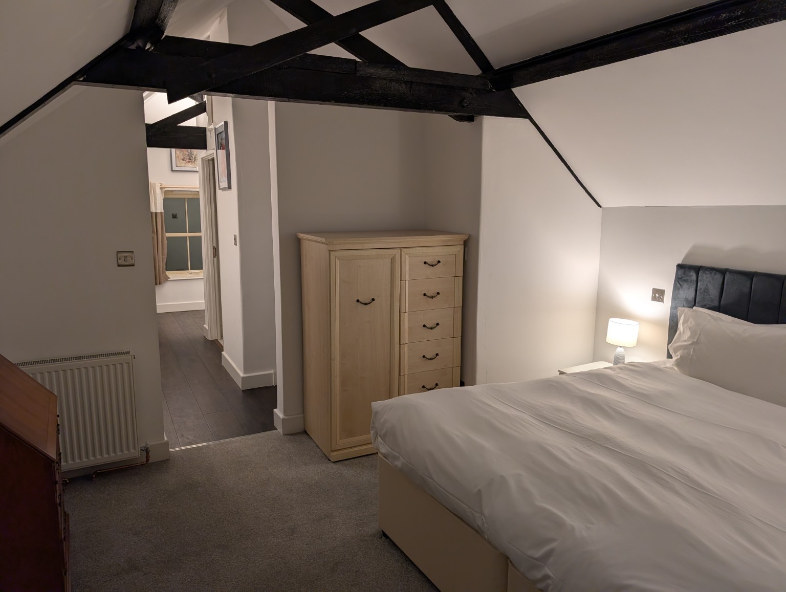 The Hayloft: the main bedroom looking through to the landing, under the beamed roof.