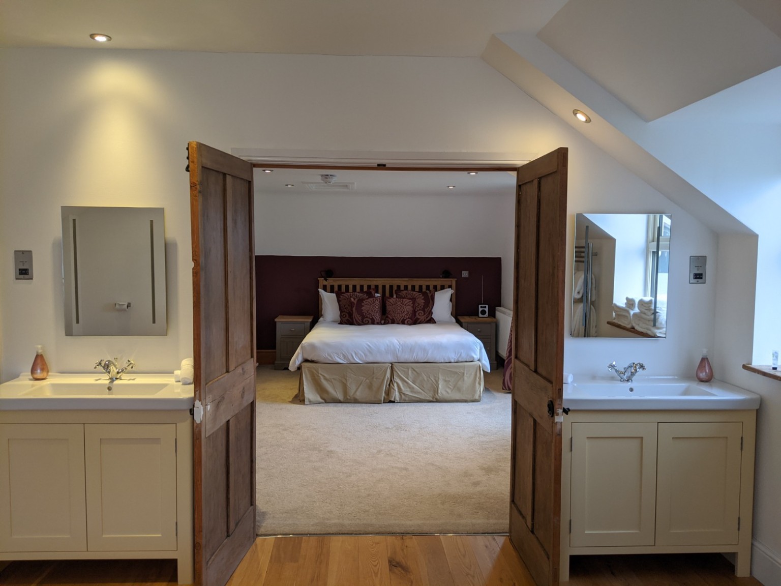 Robin: the double basins and wooden bathroom floor, looking through to the bedroom.
