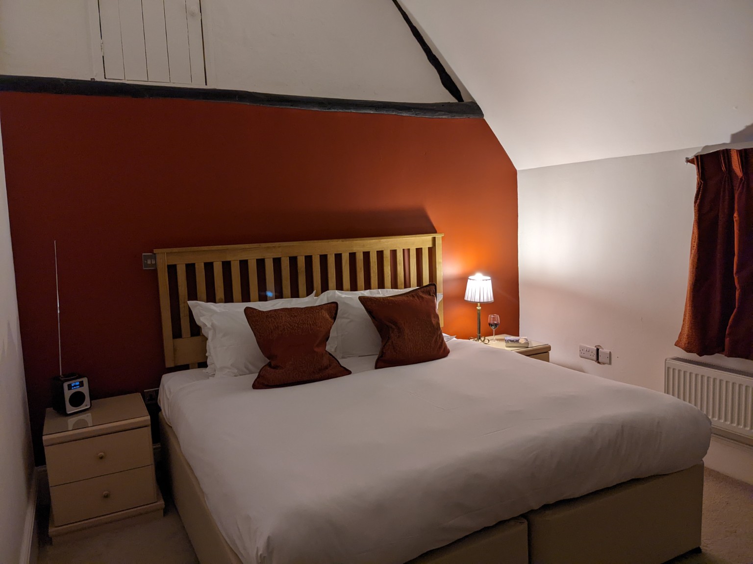 Pratchett: the king bed against the terracotta feature wall.